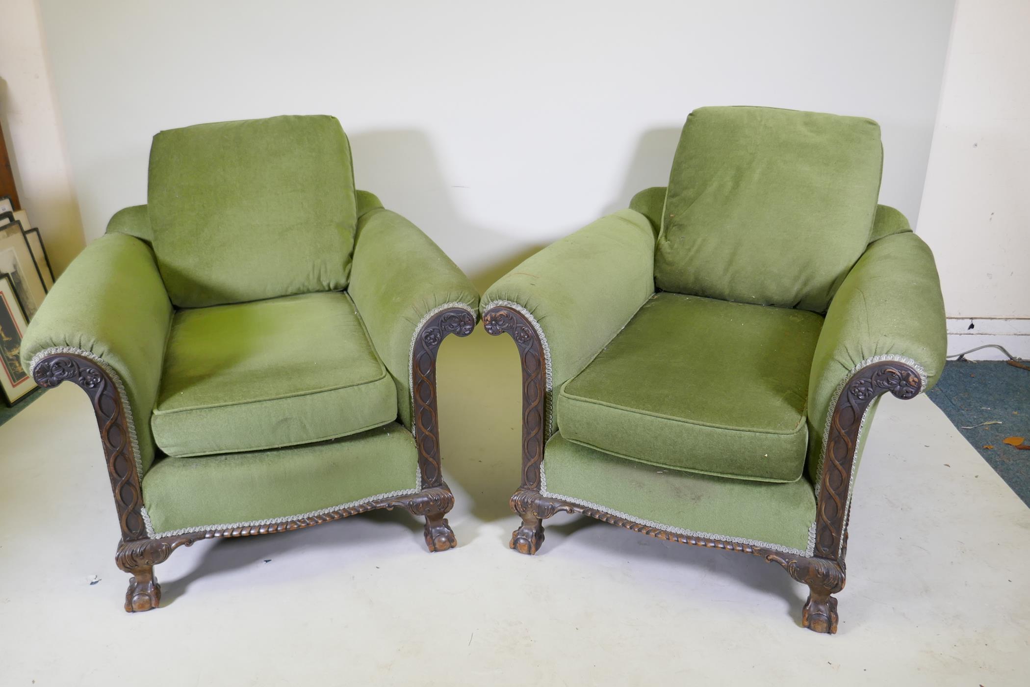 A pair of country house deep seated Chippendale style armchairs with card decoration, raised on