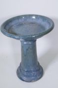 A green glazed terracotta bird bath on pedestal base, bowl 48cm diameter, 60cm high