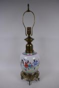 A Chinese porcelain and brass table lamp base decorated with travellers on a road, on a pierced
