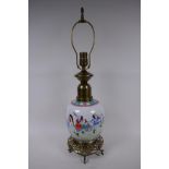 A Chinese porcelain and brass table lamp base decorated with travellers on a road, on a pierced