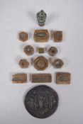 A collection of twelve antique Indian bronze jewellery moulds and two decorative bronze weights,