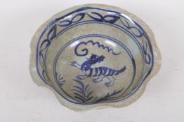 A Chinese crackleware porcelain bowl decorated with a mythical beast and flowers, 4 character mark