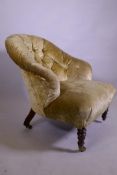 A Victorian button back tub armchair, raised on turned supports with brass castors
