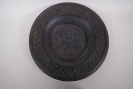 A Romanesque iron plaque/tazza top embossed with a man fighting a lion, 35cm diameter