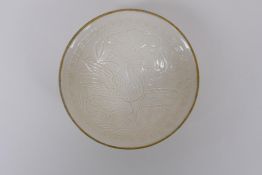A Chinese Dingware porcelain dish with raised waterfowl decoration and a gilt metal rim, marks to