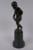 A bronze figure of Cupid delivering love letters,  raised on a turned marble socle, 28cm high