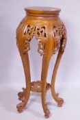 A Chinese jardiniere stand with carved and pierced details, raised on shaped supports with scroll