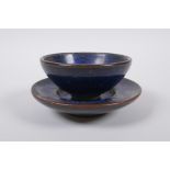 A Chinese Jian ware tea bowl and saucer with a speckled blue glaze, character marks to base, bowl
