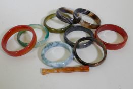 A collection of nine hardstone bangles, jadeite, agate and quartz, and a cheroot holder