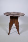 An antique Indian carved hardwood occasional table with lotus flower and lily pad decoration, 60cm