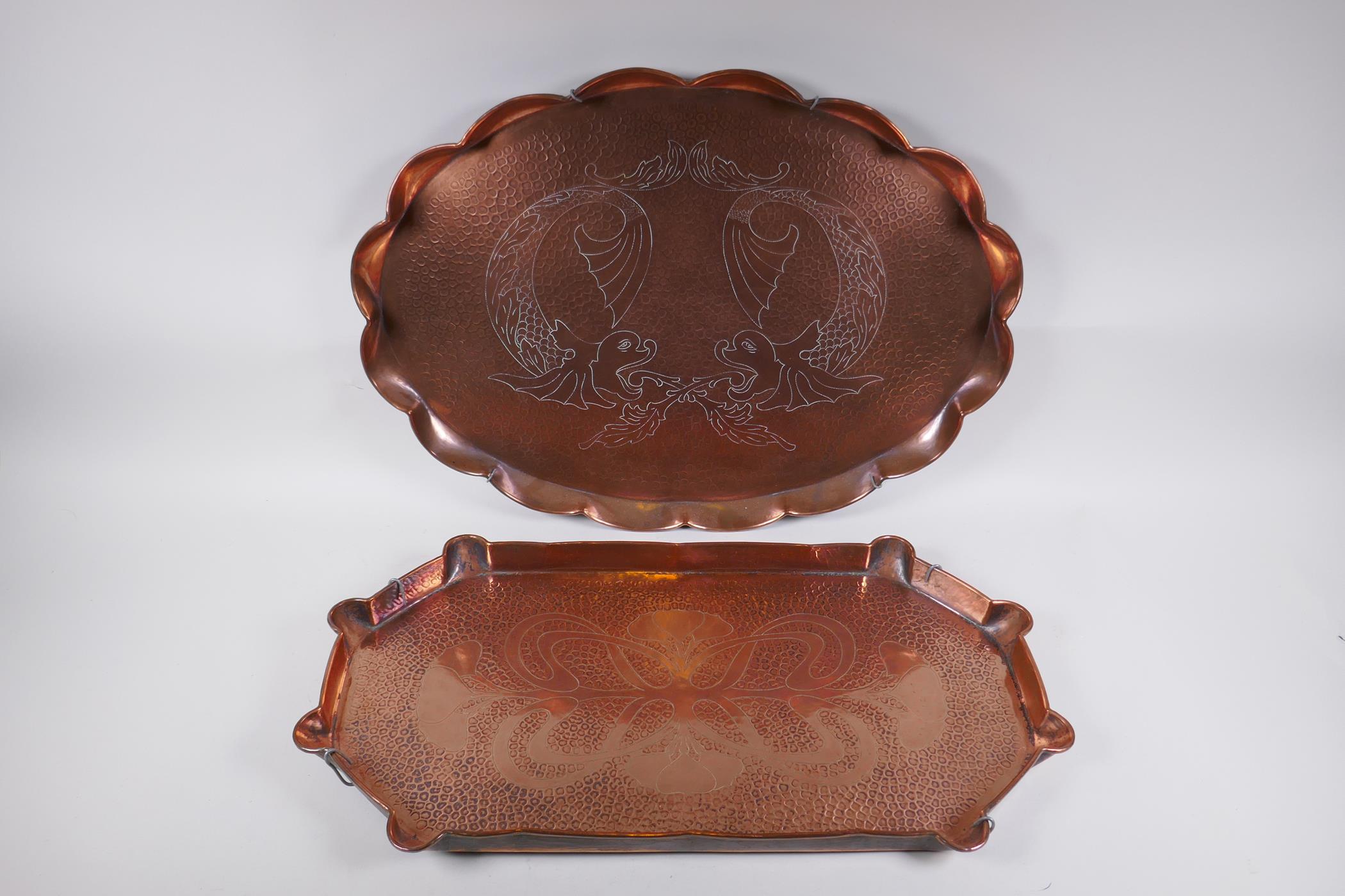 A Newlyn style hand made copper tray with dolphin decoration and another similar with Art Nouveau