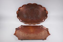 A Newlyn style hand made copper tray with dolphin decoration and another similar with Art Nouveau