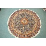 A wool carpet with Persian style designs on a red field with blue borders, 180cm diameter