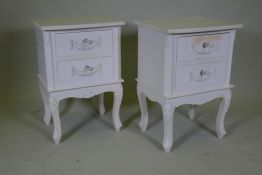 A pair of painted two drawer bedside chests, with applied decoration, raised on shaped supports,