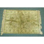 A wool silk mix rug with central design on a moss green field, 140 x 100cm