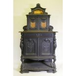 A C19th continental ebonised side cabinet, the upper section with carved decoration and two