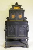 A C19th continental ebonised side cabinet, the upper section with carved decoration and two