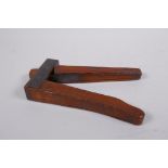 An antique walnut nut cracker with copper plates, inscribed, 19cm long