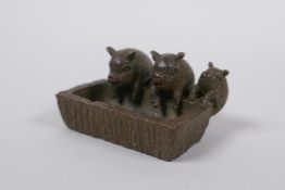 A miniature oriental bronze figure group of pigs at a trough, 5cm long
