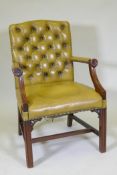 A mahogany open arm Gainsborough chair with button back leather and brass studding