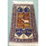 A Middle Eastern wool carpet with blue borders and terracotta field decorated with birds and beasts,