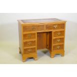 An eight drawer yew wood kneehole desk with tooled leather inset top, 91 x 50cm, 77cm high