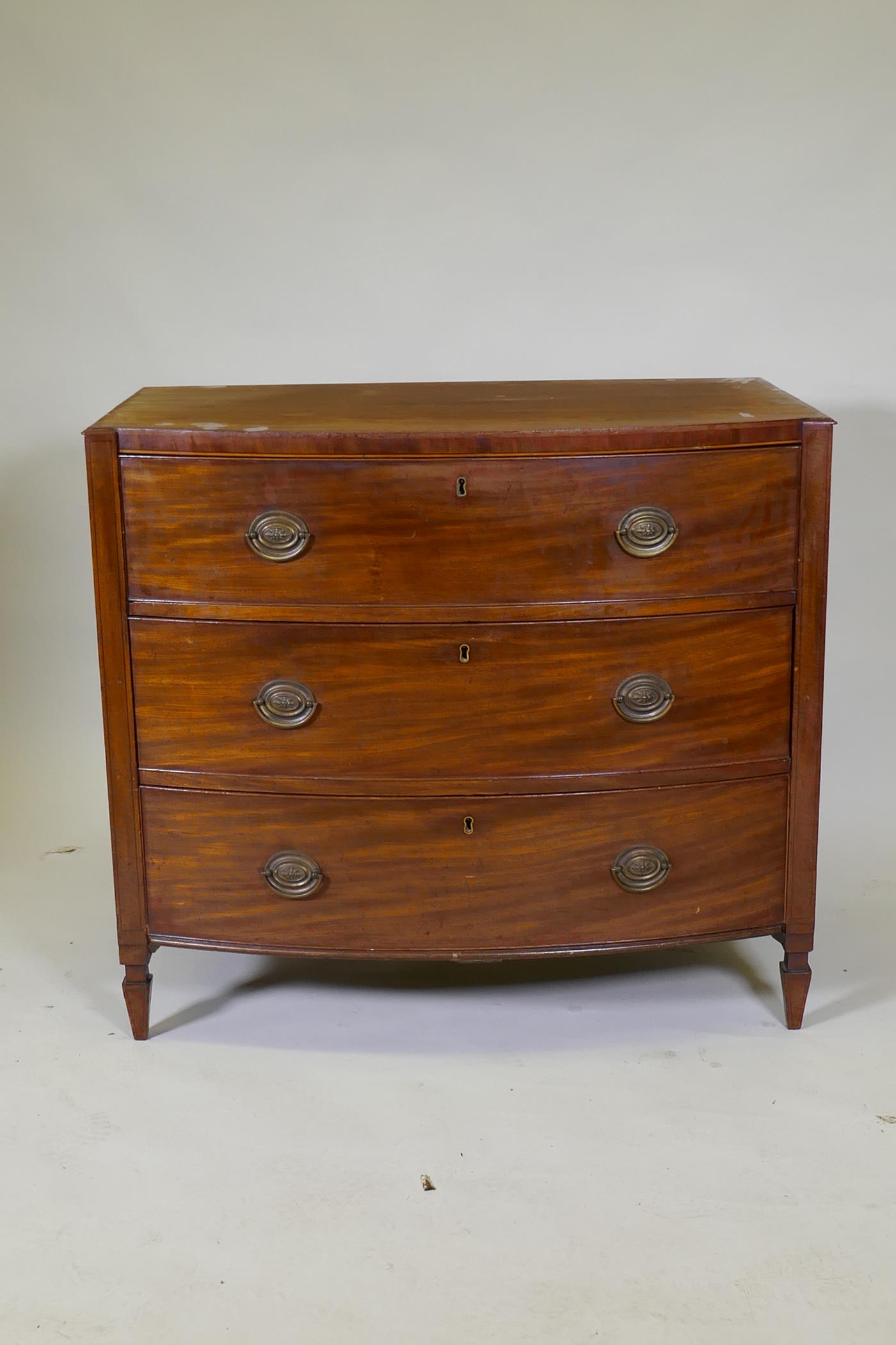 A C19th mahogany Sheraton style bow front chest of three long drawers with brass plate handles, - Image 2 of 9