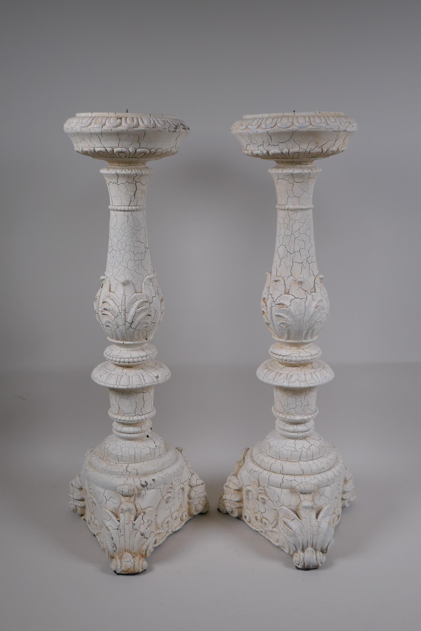 A pair of painted composition pricket candlesticks, 54cm high