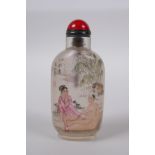 A Chinese reverse decorated glass snuff bottle depicting an erotic scene, inscription verso, 10cm