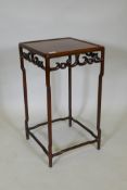 A hardwood side table/stand, with carved and pierced frieze, raised on shaped supports united by