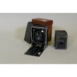 An antique camera, the lens inscribed Topaz Boyer, Paris, 15cm high, with plates and leather case,