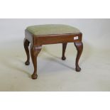 A C19th Georgian style footstool with drop in seat, raised on cabriole supports with pad feet, 47