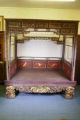 A Chinese opium bed with lacquered and carved parcel gilt decoration, 235cm wide, 153cm deep,