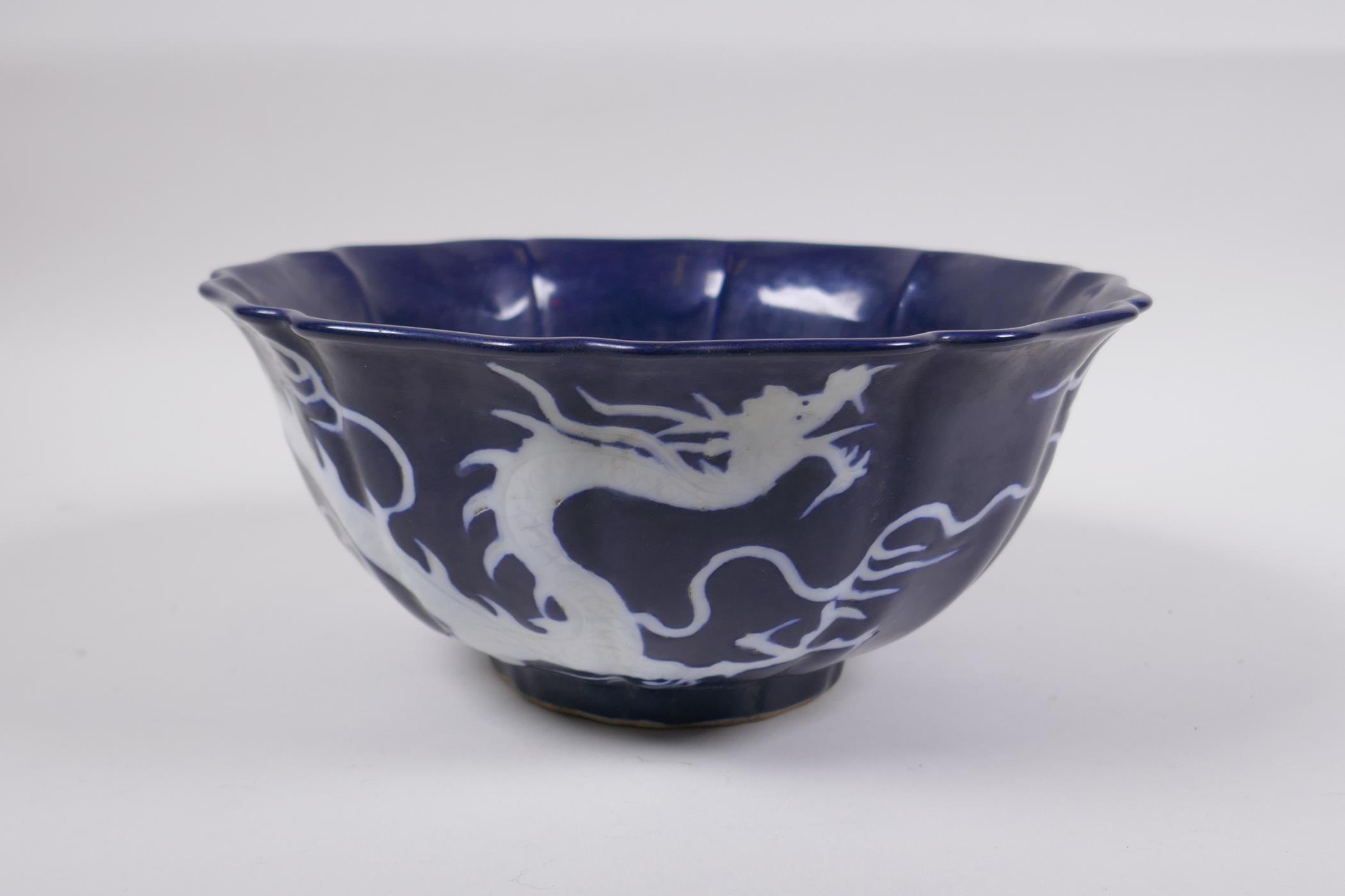 A Chinese blue and white porcelain steep sided bowl with lobed rim, decorated with a white dragon