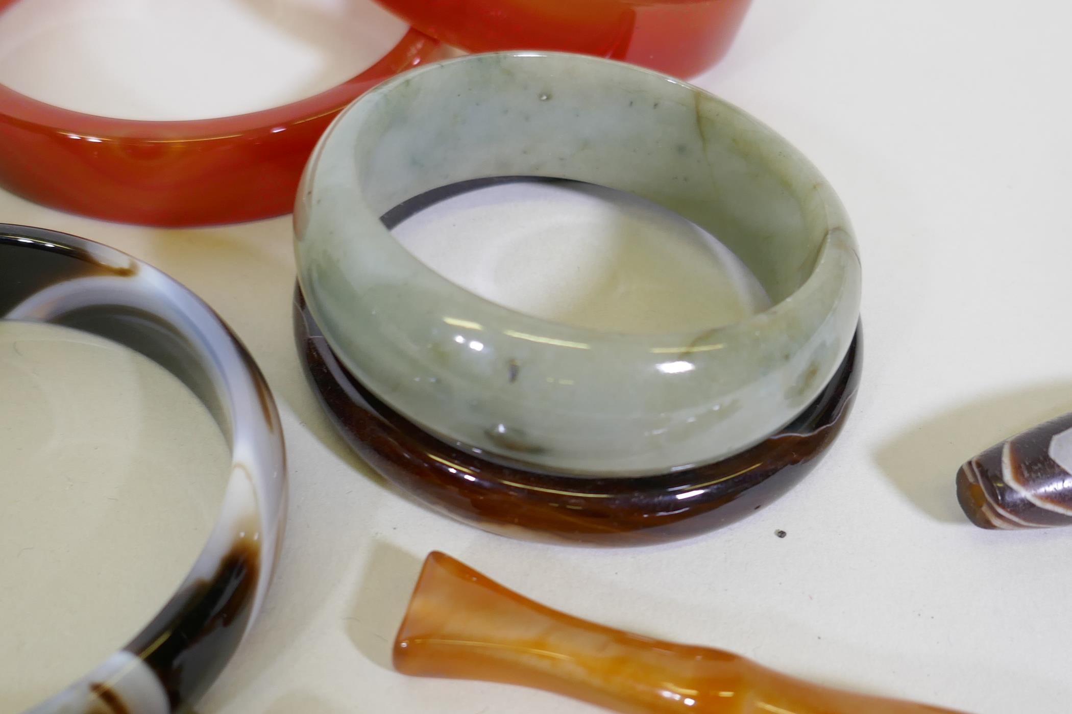 Six hardstone bangles, jadeite, agate and quartz, four cheroot holders and a dzi bead - Image 3 of 6