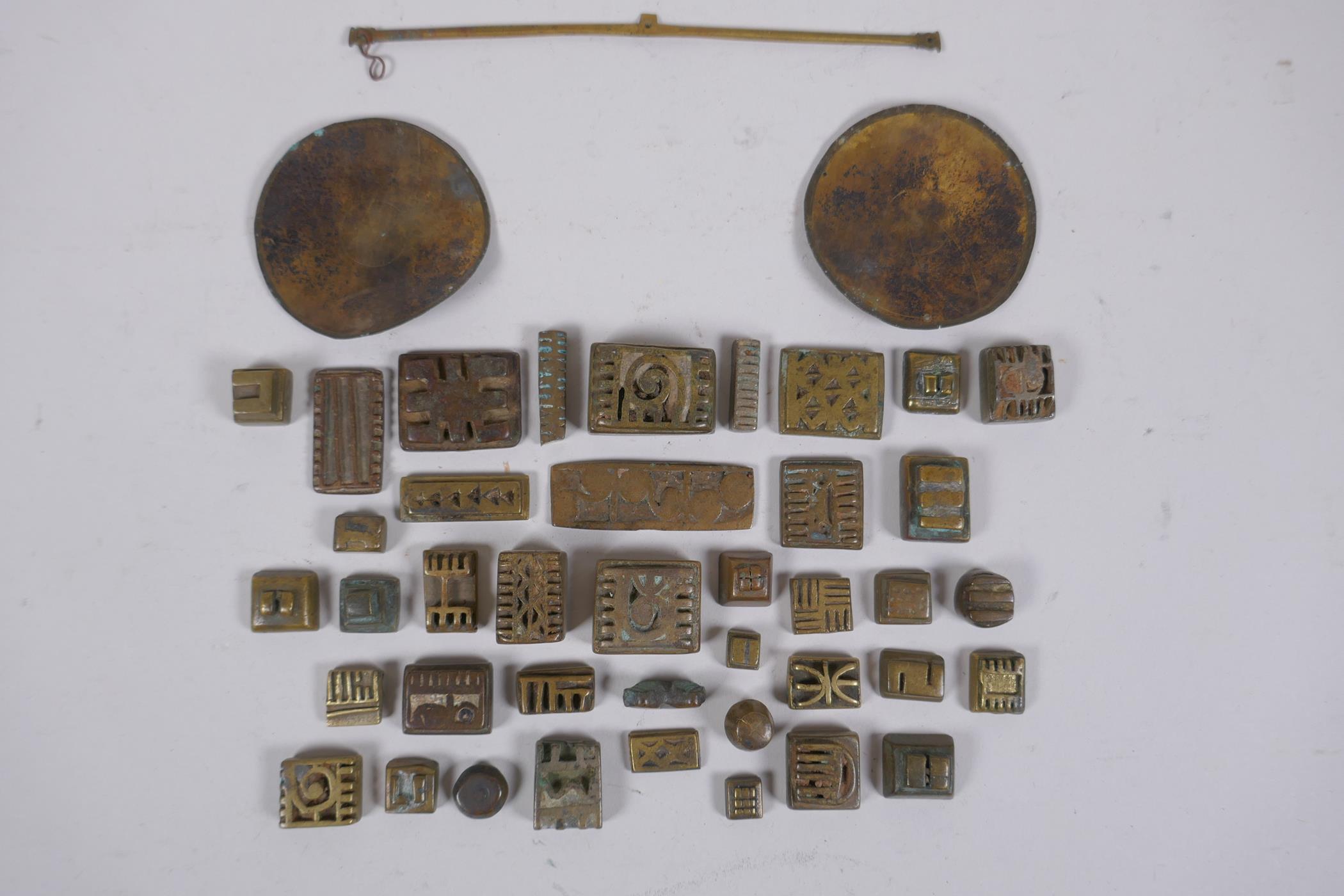 A collection of African bronze Ashanti gold weights with unique design, and a set of gold scales, AF