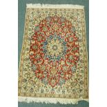 A finely woven Middle Eastern wool rug with medallion design, and scrolling decoration, 120 x 80cm