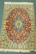 A finely woven Middle Eastern wool rug with medallion design, and scrolling decoration, 120 x 80cm