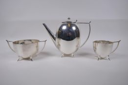 A three piece silver tea set in the manner of Christopher Dresser, 17cm high