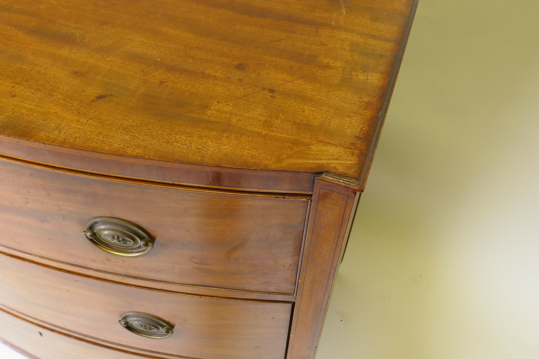 A C19th mahogany Sheraton style bow front chest of three long drawers with brass plate handles, - Image 7 of 9