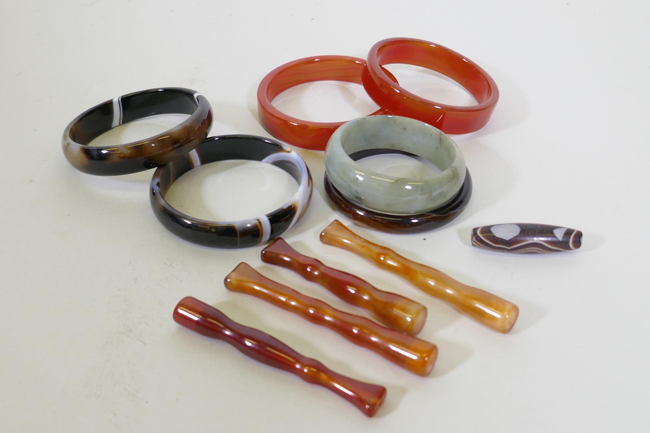 Six hardstone bangles, jadeite, agate and quartz, four cheroot holders and a dzi bead