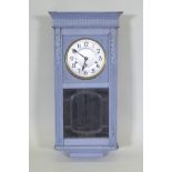 A 1920s painted oak wall clock, lacks pendulum, 38cm wide, 8cm high