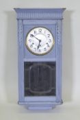 A 1920s painted oak wall clock, lacks pendulum, 38cm wide, 8cm high