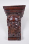 A C17th adapted carved oak bracket/term, with cherub mask decoration, 23cm