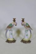 A pair of porcelain parrot candlesticks, with brass sconces and bases, 41cm high