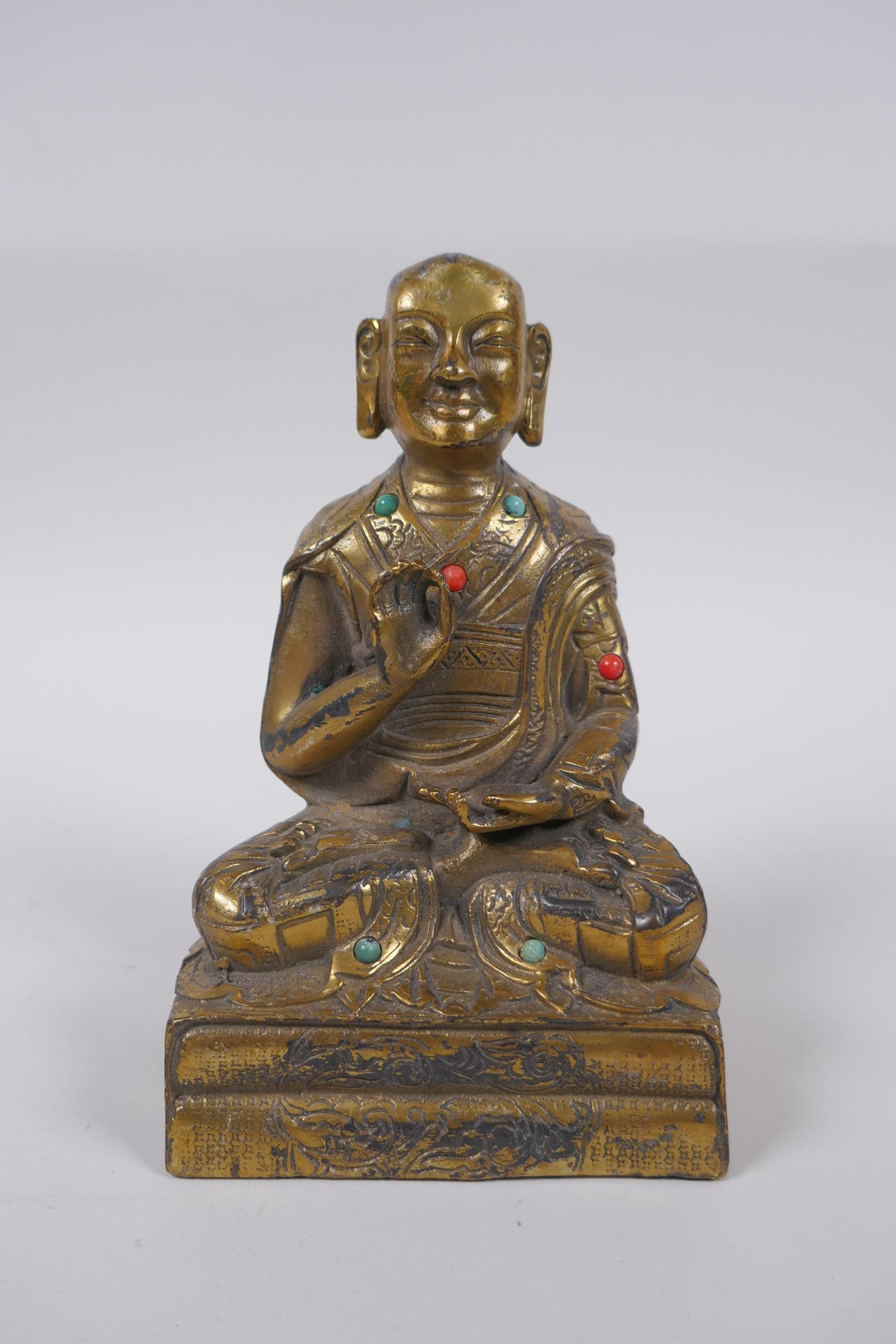 A Sino Tibetan gilt bronze figure of Buddha seated in meditation inset with semi precious stones,