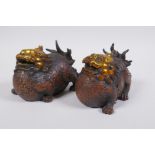 A pair of Chinese filled bronze temple lions with gilt details, 12cm long