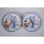 A pair of oriental porcelain shaped rim dishes with floral decoration, in an Imari palette, marks to