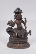 A Sino Tibetan archaic style gilt bronze figure of a wrathful deity seated on a lion, 27cm high