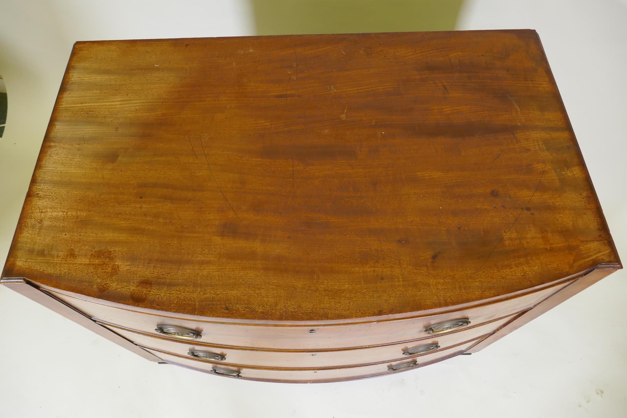 A C19th mahogany Sheraton style bow front chest of three long drawers with brass plate handles, - Image 6 of 9